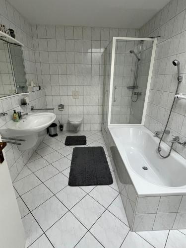 a bathroom with a tub and a sink and a toilet at Ferienhaus Altenplos in Heinersreuth