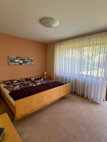 a bedroom with a bed and a large window at Ferienhaus Altenplos in Heinersreuth