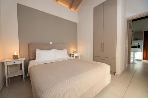 a bedroom with a large white bed with two night stands at Mary's Panorama Houses in Gialova