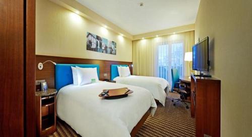 a hotel room with two beds and a flat screen tv at Hampton By Hilton Ordu in Ordu