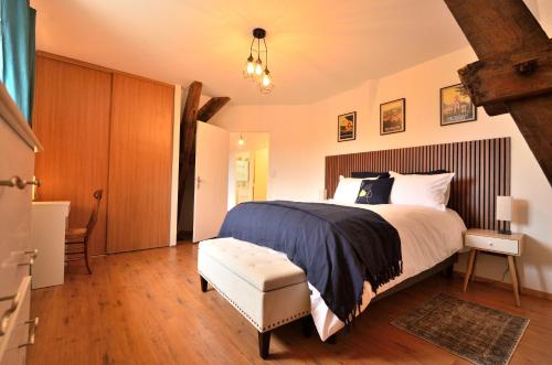 a bedroom with a large bed and a bench in it at La Villa du Mont in Gourdon