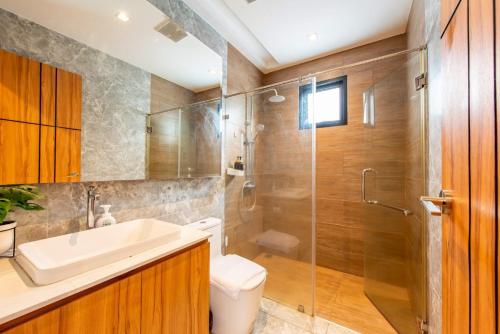 a bathroom with a shower and a toilet and a sink at TheH Pool Villa in Nong Prue