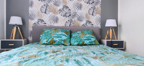 une chambre avec un lit à tête de lit et deux lampes dans l'établissement Le scandinave, à Douai