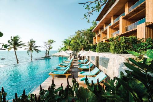 a row of chairs and umbrellas next to a swimming pool at Cape Dara Resort in North Pattaya