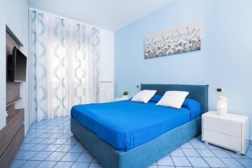 a bedroom with a blue bed and a television at I Tre Delfini apartment in center-Sorrento Coast in Vico Equense