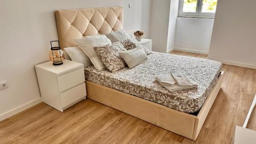 a bedroom with a large bed with a large headboard at Cantinho da Nina in Arcos de Valdevez