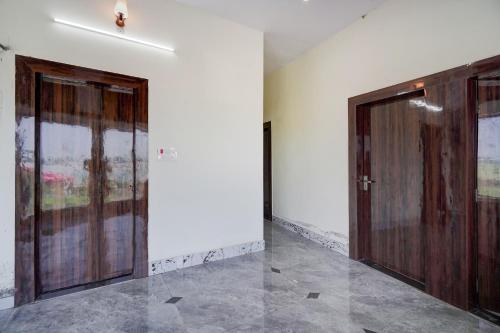two wooden doors in a room with a tile floor at Hotel O Highway Kitchen in Bara Khera