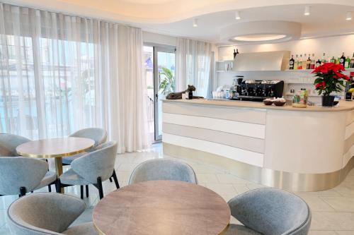 a kitchen with blue chairs and a counter with tables at Hotel Regal in Rimini