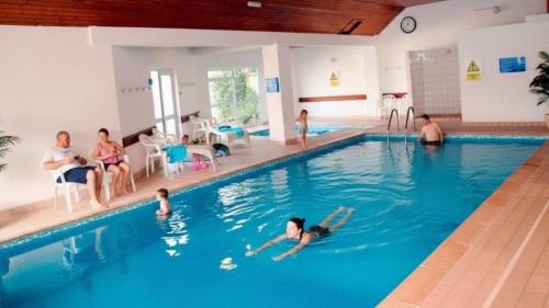 a group of people swimming in a swimming pool at PUTSBOROUGH CLIFTON COURT 17 1 Bedroom in Croyde