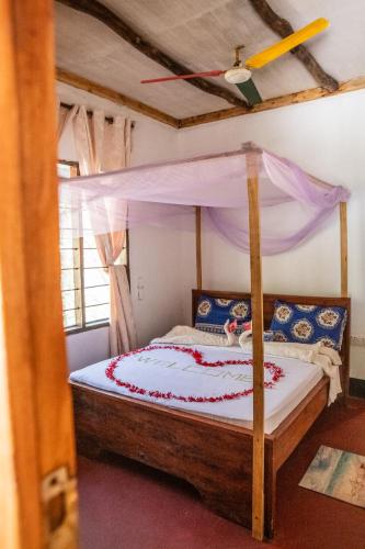 a bedroom with a bed with a canopy at Afro Beach Safari in Kilindoni