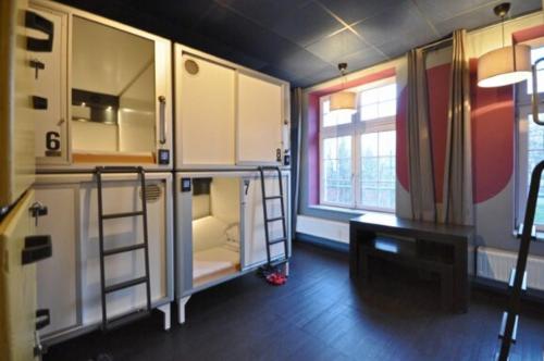 a room with a kitchen with a bunk bed and a desk at Singer109 Hostel, Hotel & Apartment in Berlin