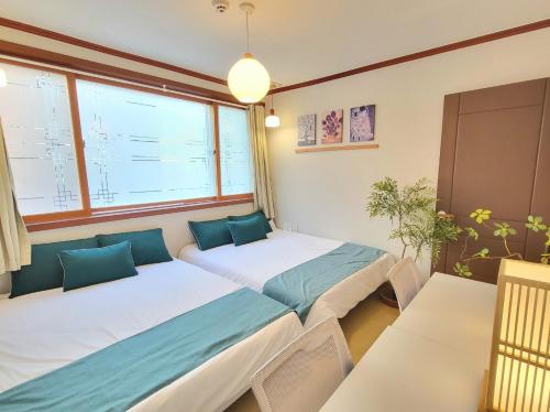a bedroom with two beds and a window at 대구 K Stay in Daegu
