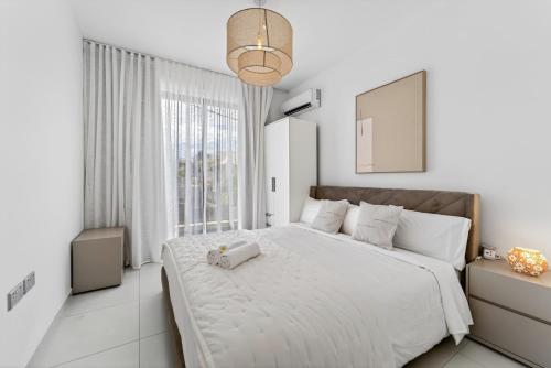 a white bedroom with a large bed and a window at Rooftop & Jacuzzi privé à 5 min de la plage in Flic-en-Flac