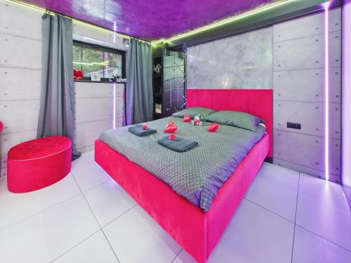 a red bed in a room with a purple ceiling at LoveAparts Marki Romantic Stay in Marki
