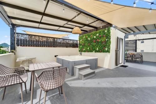 a patio with a table and chairs and a plant at Rooftop & Jacuzzi privé à 5 min de la plage in Flic-en-Flac