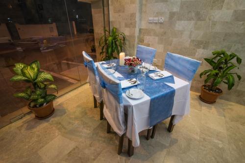 una mesa con un mantel azul y blanco en Al Mawaleh Furnished Flats & Rooms, en Mawāliḩ