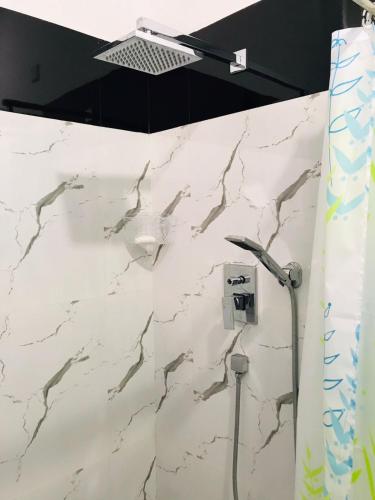 a shower in a bathroom with a marble wall at Marissa Villa in Katunayaka