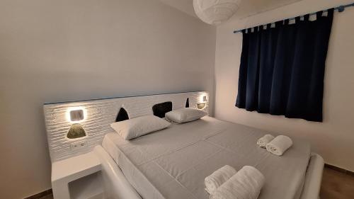 a white bed with two pillows in a bedroom at Chryssa Bungalows in Andros