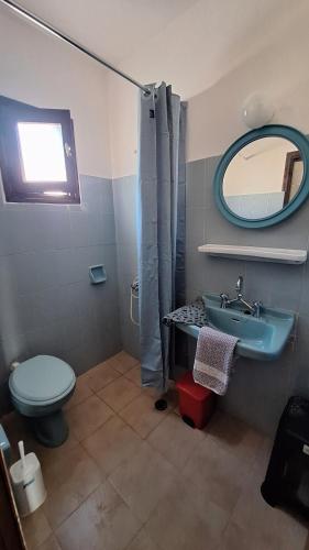 a bathroom with a sink and a toilet and a mirror at Chryssa Bungalows in Andros