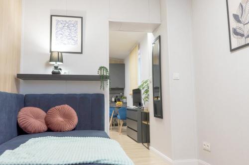 a living room with a blue couch and a kitchen at Willa na Dębowej in Katowice