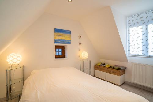 a bedroom with a white bed and a window at Au nid d'Alsace - SPA et sauna privé in Orschwiller