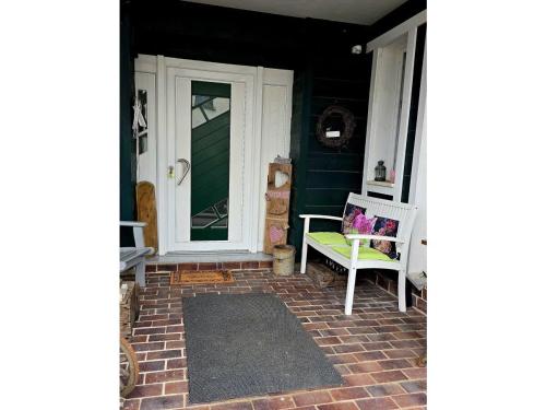 a front porch with a green door and a bench at Ferienwohnung Das grüne Haus in Byhlen