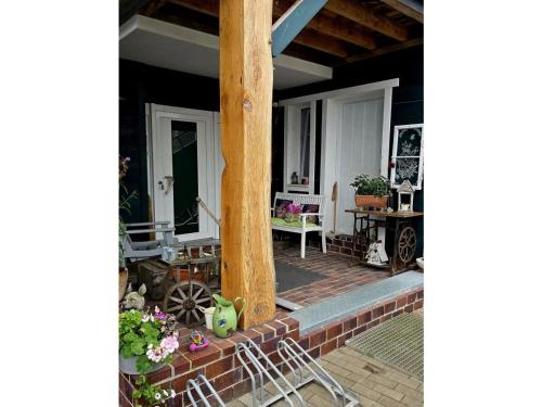 a porch of a house with a wooden pole at Ferienwohnung Das grüne Haus in Byhlen