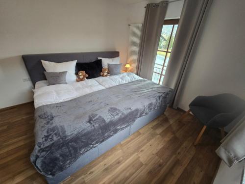 a bedroom with a bed with two teddy bears on it at Ferienwohnung Wilde Hilde inklusive aktivCARD in Arrach