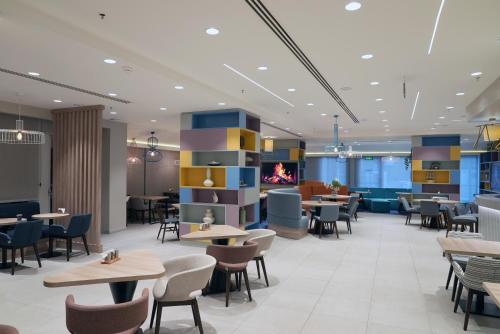 a restaurant with tables and chairs and a fireplace at Hampton By Hilton Ordu in Ordu