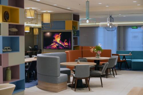 a restaurant with tables and chairs and a fireplace at Hampton By Hilton Ordu in Ordu