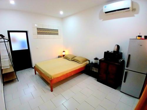 a bedroom with a bed and a refrigerator in it at Cozy Studio with Private Jacuzzi and Pool! in Saly Portudal