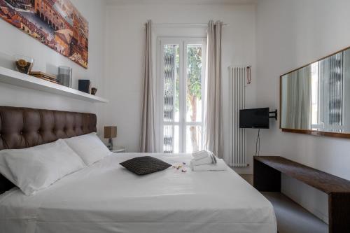 a bedroom with a large white bed and a window at Bologna Suite in Bologna