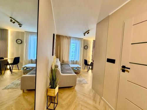 a living room with a couch and a table at Fly Apartment Modlin by JumpInHere in Nowy Dwór Mazowiecki
