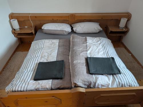 a wooden bed with two pillows on it at Ferienwohnung Niklas in Saulgrub