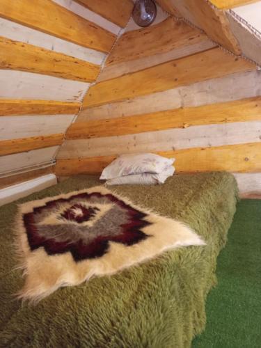 a bed in a room with a wooden ceiling at Гірська яфина in Myta