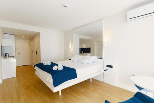 a white bedroom with a large bed and a table at Hotel sea view in Batumi