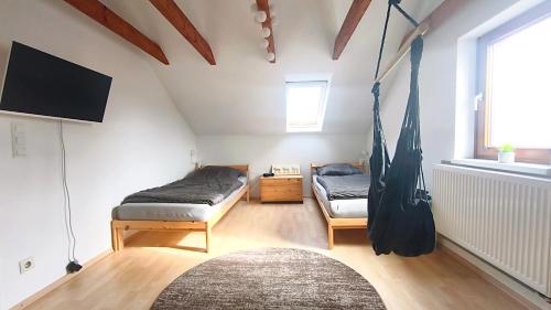 a room with two beds and a flat screen tv at Gemütliches, ruhiges Zimmer mit eigenem Bad in Werther