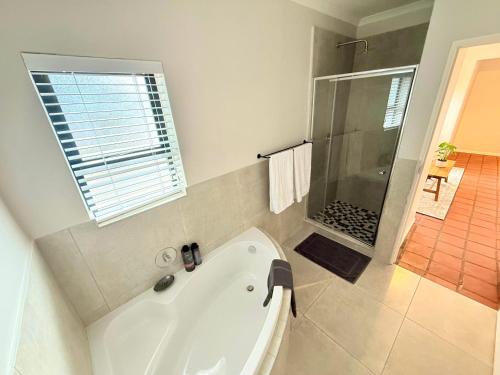 a white bath tub in a bathroom with a shower at Die Stal in Wellington