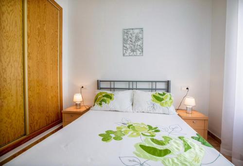 a bedroom with a bed with two night stands and two lamps at Bluemoon in Mazarrón