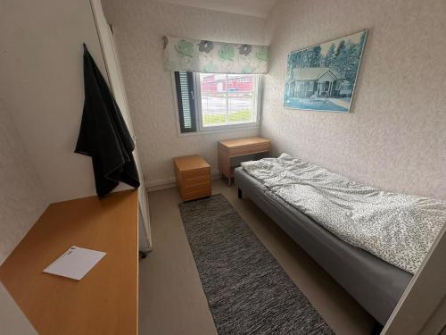 a small bedroom with a bed and a desk at Affordable, fully equipped practical housing! in Laivaniemi