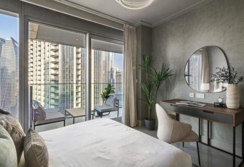 a bedroom with a bed and a desk and a large window at Luxurious Private Room in Burj Vista with Burj Khalifa View in Dubai