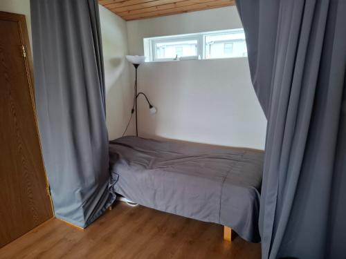 a small bed in a room with a window at Sigtun 55 in Patreksfjörður
