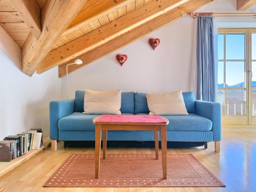 a blue couch in a living room with a table at Sonnenhof Seeg 17 in Seeg