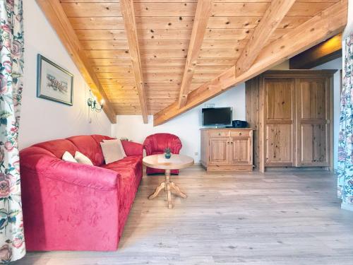a living room with a red couch and a table at Sonnenhof Seeg 16 in Seeg