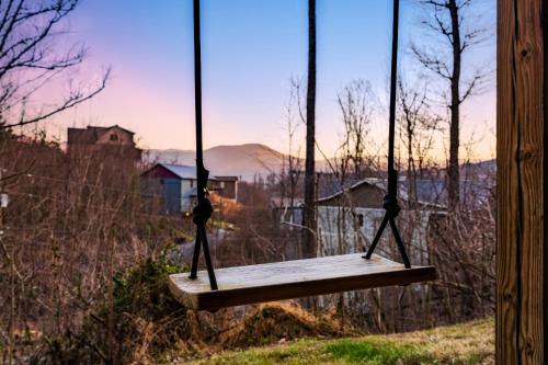 a swing with a person sitting on it at Take It Easy - 5 Star Family Cabin View Hot Tub FirePit Pools Bears in Gatlinburg