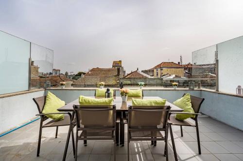 a table and chairs on a balcony with a view at Art City Villa in Porto