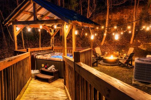a wooden deck with a hot tub and lights at Take It Easy - 5 Star Family Cabin View Hot Tub FirePit Pools Bears in Gatlinburg