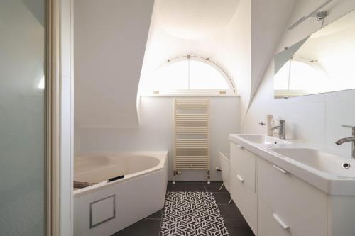 a white bathroom with a tub and a sink at Villa Seaview met Sauna in Makkum