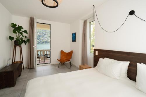 a bedroom with a large bed and a balcony at Villa Patria B&B in Brusino Arsizio