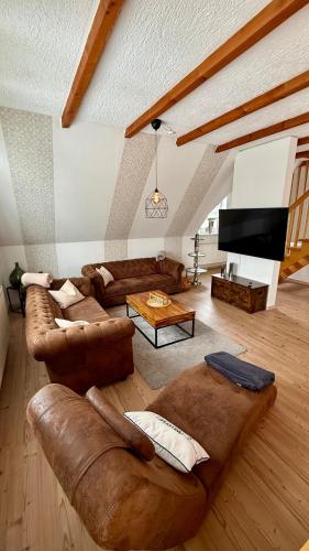 a living room with couches and a flat screen tv at Ferienwohnung Lerchi's Ankerplatz in Barßel